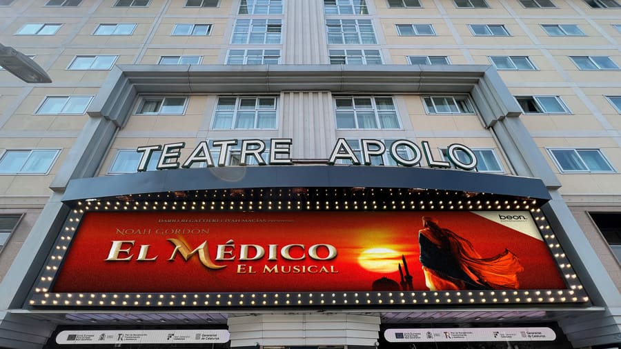 Fachada del Teatro Apolo con el cartel del musical 'El Médico', destacando la entrada principal y la promoción del espectáculo